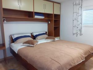 um quarto com uma cama grande e uma grande cabeceira. em Villa PANORAMA em Pag