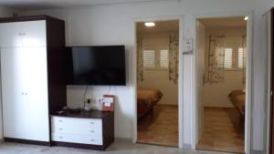 uma sala de estar com televisão e um quarto em Villa PANORAMA em Pag