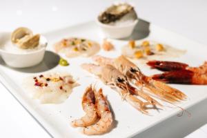 a plate of food with shrimp and other foods at Hotel Hvala Superior - Topli Val in Kobarid