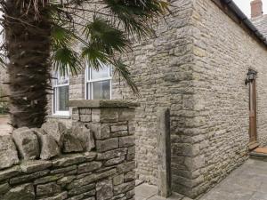 a stone building with a palm tree next to it at The Old Haberdashery in Swanage