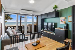 a kitchen and living room with a view of the ocean at Rawsons shack Beachfront unit suits single or couple in Henley Beach South +12 photos