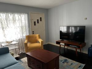 - un salon avec un canapé, une télévision et une chaise dans l'établissement Park View East, à Lakeland