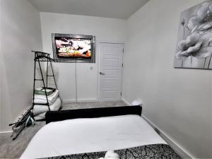 1 dormitorio con 1 cama y TV en la pared en 16A Ground floor setup for your most amazing relaxed stay Free Parking Free Fast WiFi, en Morley