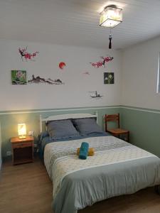 um quarto com uma cama com um bicho de peluche em Une pause avec recharge voiture électrique em Saint-Médard-de-Guizières