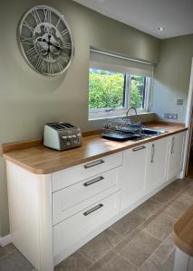 uma cozinha com um balcão com um relógio na parede em 3-bedroom bungalow, central Ambleside with parking em Ambleside
