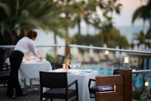 Una donna seduta a un tavolo in un ristorante di Mediterranean Beach Hotel a Limassol