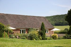 a wooden house with a green field and trees at Pheasant Walk at Eaton Manor in Church Stretton