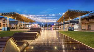 una plaza de la ciudad iluminada con bancos y luces en Rawsons shack Beachfront unit suits single or couple en Henley Beach South