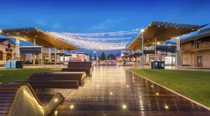 a lit up city square with benches and lights at Rawsons shack Beachfront unit suits single or couple in Henley Beach South