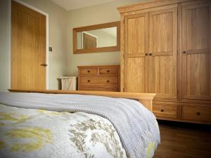 a bedroom with a bed and a large wooden cabinet at 3-bedroom bungalow, central Ambleside with parking in Ambleside