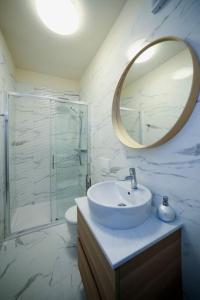 a white bathroom with a sink and a mirror at New renovated appartment Mauri in Poreč
