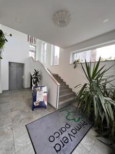 een woonkamer met een trap en een tapijt bij Hotel PrimaVera parco in Fürth