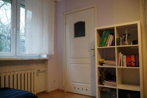 een kamer met een deur en een boekenplank met boeken bij Apartament Parterowy in Poznań