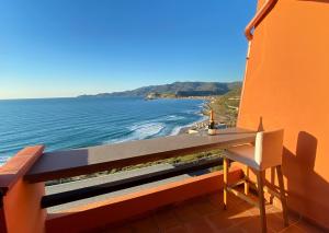 Panoramica casa al mare في بوسا: شرفة مع طاولة وكرسي والمحيط