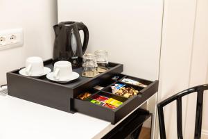 a black drawer with dishes and a coffee pot on it at La finestra sul canale in Bologna