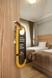 a doorhandle to a room with a room with a bed at Konuk Hotel in Eskisehir