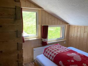a bedroom with two windows and a bed in it at Bauernhaus Cafrida in Flumserberg