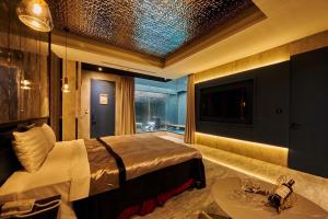 a bedroom with a bed and a tv and a table at In Night Hotel in Taichung