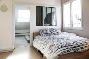 a bedroom with a large bed with a window at L'atticisme : Jacuzzi & Parking in Voiron