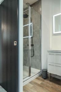 a shower with a glass door in a bathroom at L'atticisme : Jacuzzi & Parking in Voiron