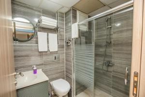 a bathroom with a shower and a toilet and a sink at Konuk Hotel in Eskisehir