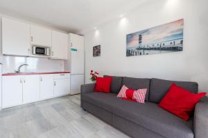 - un salon avec un canapé gris et des oreillers rouges dans l'établissement Lovely seaview apartment, à Benalmádena