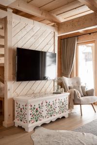 un soggiorno con TV a parete di Osada Roztoki - Luxury Chalets a Kościelisko
