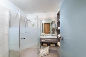 ein Badezimmer mit Glasdusche und Waschbecken in der Unterkunft Hotel Sommer-Haus am See in Füssen