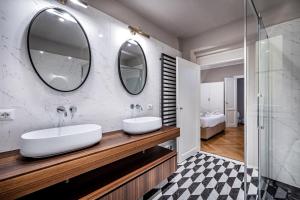 a bathroom with two sinks and two mirrors at Hs4U Ricasoli Luxury apartment near Duomo N. 3 in Florence