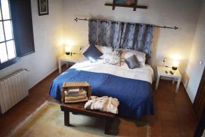 a bedroom with a bed with a blue comforter at Casa KiSi Cottage, Rural Boutique Bed & Breakfast in Málaga +37 photos