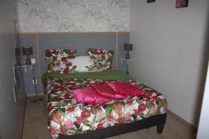 - un lit avec des oreillers roses dans l'établissement Gite De LA BALLADE, à François