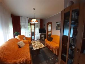 フォニョードにあるSzőke Nyaralóのリビングルーム(オレンジ色のソファ2台、テーブル付)