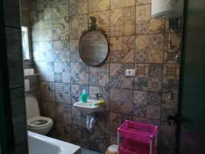 a bathroom with a sink and a toilet and a mirror at Apartmani Radić Rg in Rogoznica