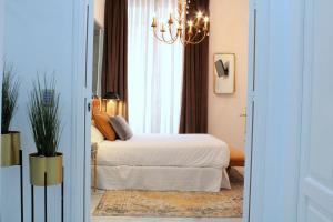 1 dormitorio con cama y lámpara de araña en Hostal Roomsole, en Sevilla