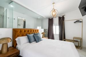 1 dormitorio con 1 cama blanca grande con almohadas azules en Hostal Roomsole, en Sevilla
