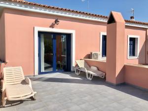 un patio con due sedie e una casa di Traditional House at Aegina Port a Città di Egina