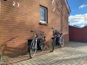 Dos bicicletas están estacionadas contra una pared de ladrillo. en Ferienhuus En Söten, en Bedekaspel