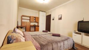 a bedroom with two beds and a flat screen tv at Водопійна 19 CityRooms in Bila Tserkva