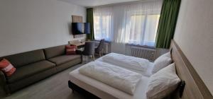 pokój hotelowy z łóżkiem i kanapą w obiekcie Hotel Ladage w Frankfurcie nad Menem