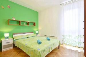 a bedroom with a bed with a green wall at Apartment Vicko in Omiš