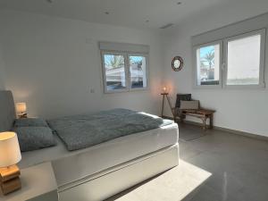 um quarto branco com uma cama e 2 janelas em Moderne Finca in Strandnähe em Orihuela