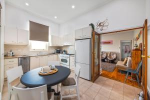 a kitchen with a table and a kitchen with a dining room at Kerrigan's on Seaview- one minute walk to beach - not beachfront in Henley Beach