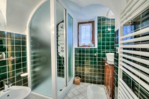 a green tiled bathroom with a shower and a sink at Apartments In The Heart of Medieval Village - Happy Rentals in Apricale
