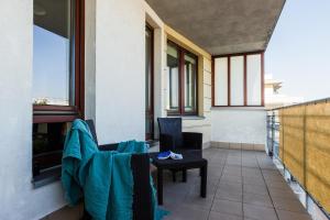 a balcony with chairs and a table and windows at ShortStayPoland Grodkowska (B114) in Warsaw