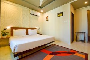 a bedroom with a white bed and a rug at FabHotel Manomay Stays I- Nagpur Airport in Nagpur