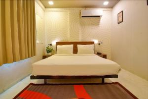 a bedroom with a bed and a red rug at FabHotel Manomay Stays I- Nagpur Airport in Nagpur