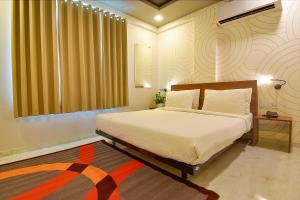 a bedroom with a large bed and a rug at FabHotel Manomay Stays I- Nagpur Airport in Nagpur