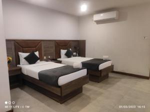 a hotel room with two beds in a room at HOTEL K79 in Jamshedpur