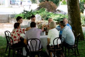 a group of people sitting around a table with wine glasses at Hotel Hvala Superior - Topli Val in Kobarid