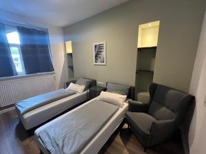 Zimmer mit 2 Betten, einem Stuhl und einem Fenster in der Unterkunft English Romance Exclusive Apartments in Hannover